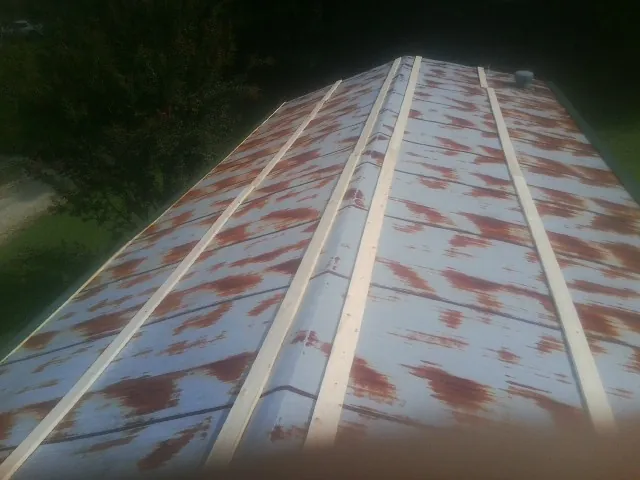 Rusted metal roof panels with new wood purlins before replacement — Storm Damage Roof Repair in North Haverhill by Roofing Brothers