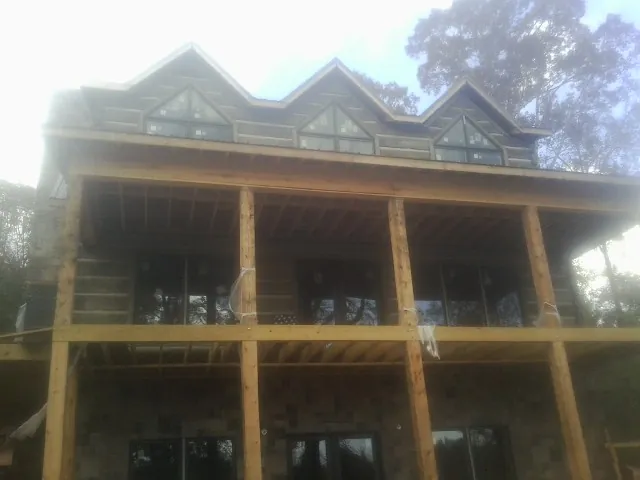 Dormers and porch framing on a large log home under construction — Roof Coating work by our crew in North Haverhill