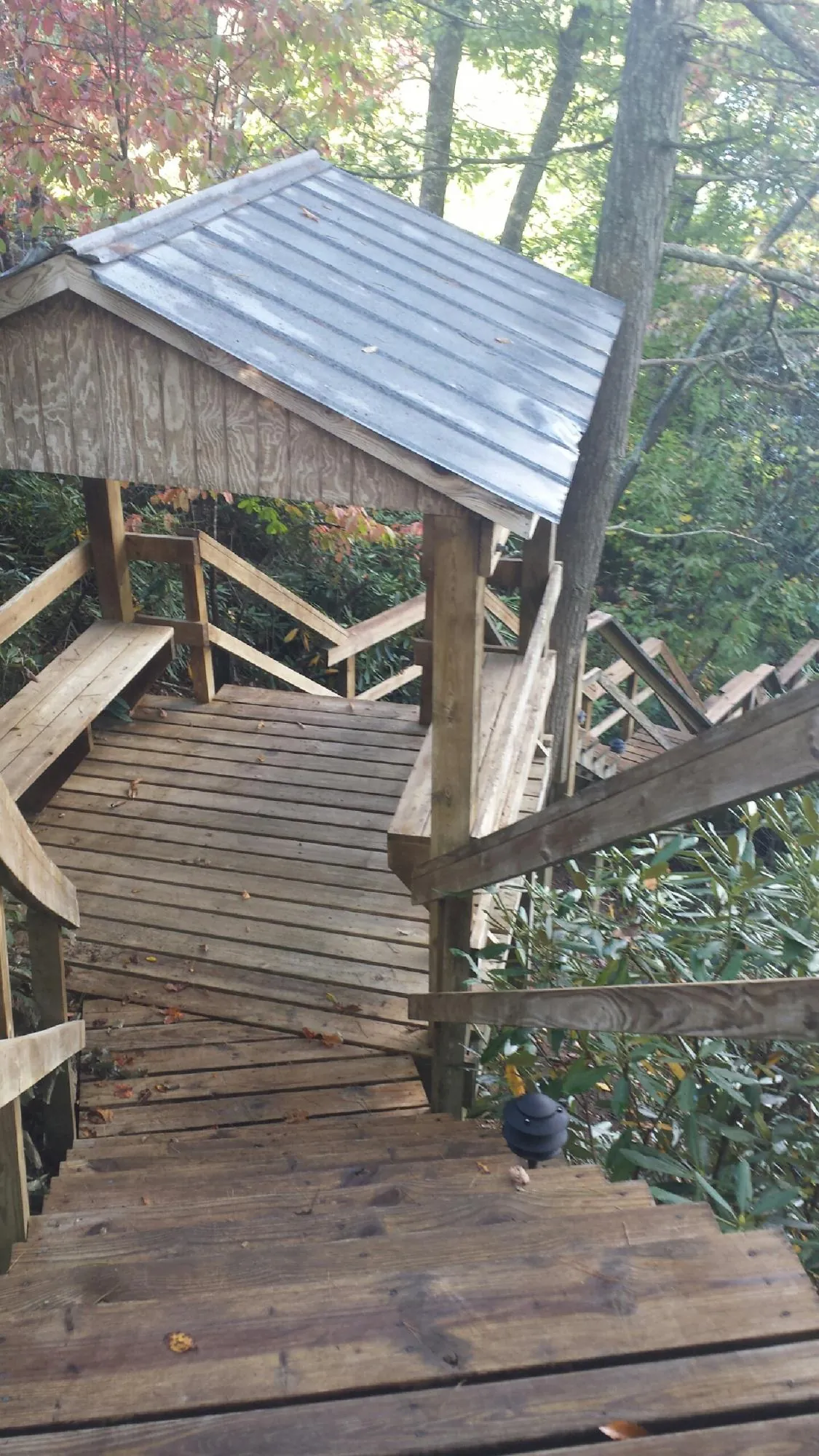 Metal roofed shelter over wooden steps on a wooded walkway — Skylight Repair & Installation work by our crew in North Haverhill